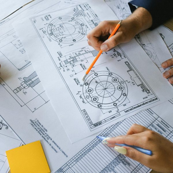 From above of crop anonymous businesspeople discussing project on papers at table of office in daytime